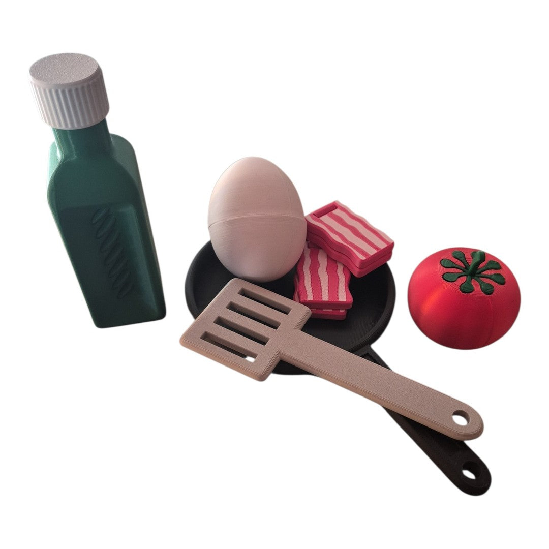 Peças do Kit Breakfast: garrafinha, ovo, bacon, tomate, espátula e frigideira