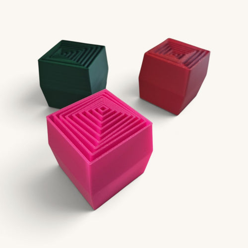 Cubo Expansível Sense em três cores: verde, vermelho e rosa, fechados em cubo