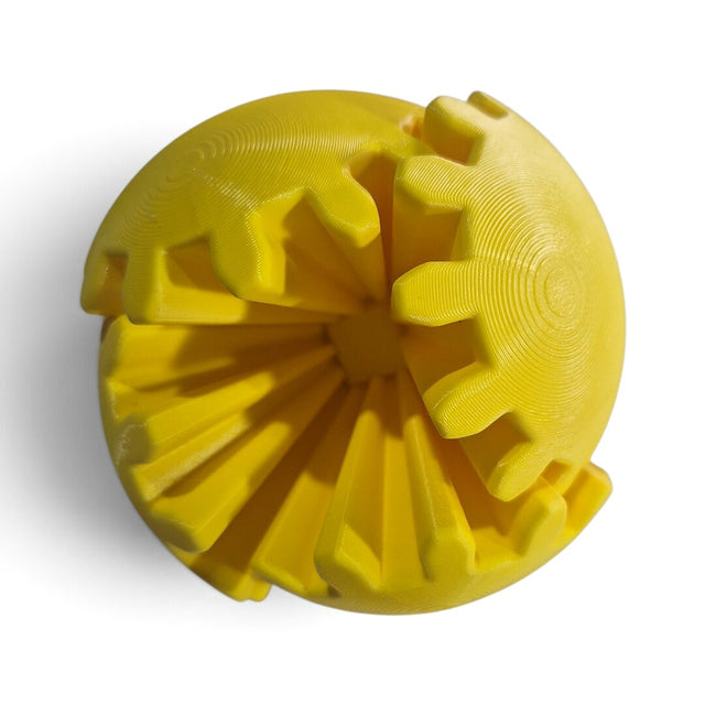 Gear Ball Sense fechada: bola amarela de gomos dentados com as engrenagens pretas à mostra