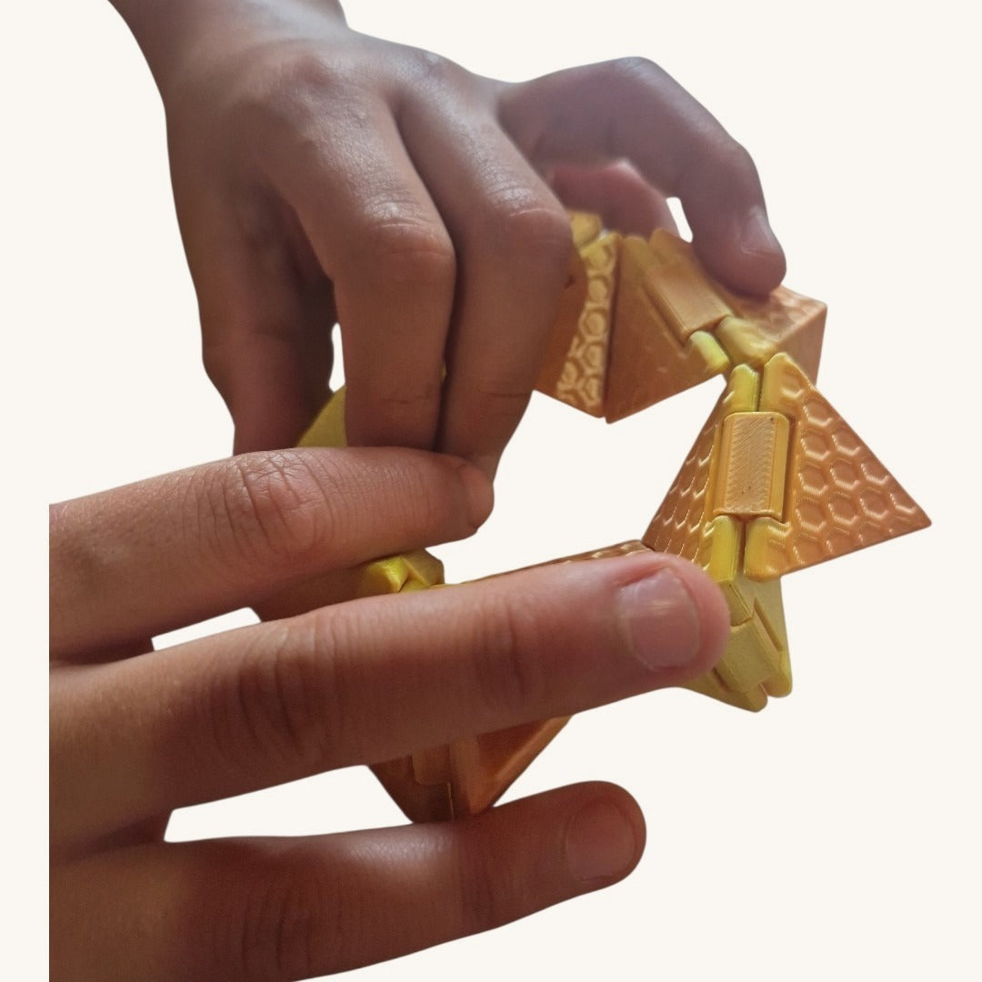 Mãos dobrando o Cubo Origami no meio da transformação